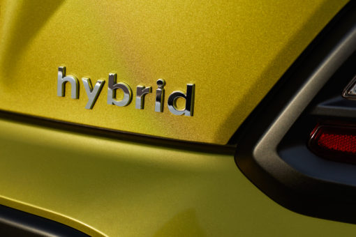 Chromed hybrid car logo on green background